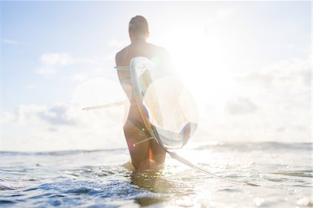 Rear view of woman carrying surfboard in sunlit sea, Nosara, Guanacaste Province, Costa Rica Stockbilder - Premium RF Lizenzfrei, Bildnummer: 649-08900729