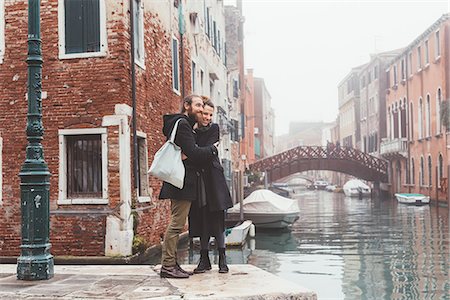 Couple hugging on misty canal waterfront, Venice, Italy Stock Photo - Premium Royalty-Free, Code: 649-08900835