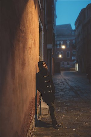 Portrait of man leaning against street wall at dusk, Venice, Italy Stock Photo - Premium Royalty-Free, Code: 649-08900884