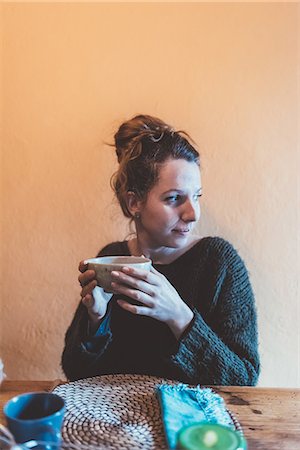 simsearch:649-08840719,k - Young woman holding bowl at kitchen table Foto de stock - Royalty Free Premium, Número: 649-08900889