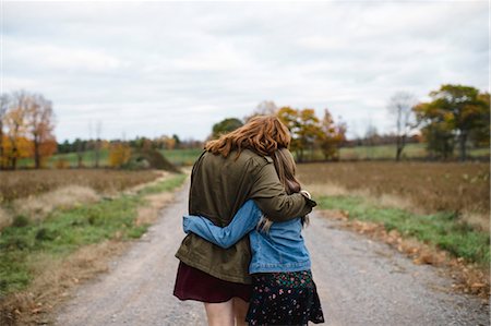 Mother and daughter hugging on dirt road, Lakefield, Ontario, Canada Fotografie stock - Premium Royalty-Free, Codice: 649-08900925