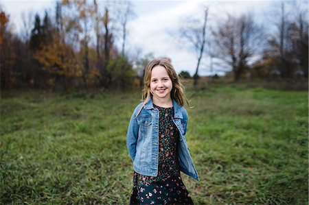 Young girl smiling in field in denim jacket, Lakefield, Ontario, Canada Fotografie stock - Premium Royalty-Free, Codice: 649-08900935