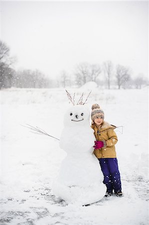 Girl shovelling snow in front of snowman, Lakefield, Ontario, Canada Fotografie stock - Premium Royalty-Free, Codice: 649-08900945