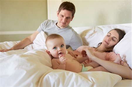 simsearch:614-03684171,k - Portrait of baby girl lying on bed with parents Foto de stock - Royalty Free Premium, Número: 649-08900994