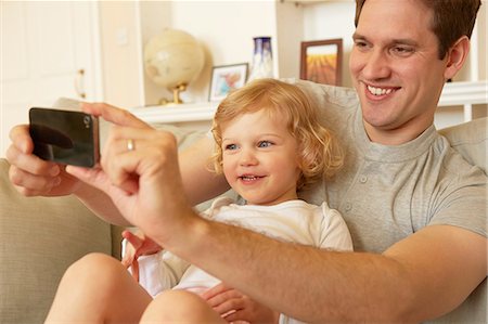 simsearch:649-08901538,k - Female toddler sitting on father's knee taking smartphone selfie Stock Photo - Premium Royalty-Free, Code: 649-08901021