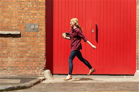 pic of person running into brick wall - Woman walking past red door, London, UK Stock Photo - Premium Royalty-Free, Code: 649-08901043