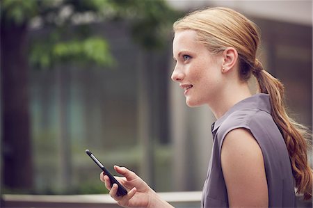 simsearch:649-08901059,k - Woman using mobile phone in street, London, UK Photographie de stock - Premium Libres de Droits, Code: 649-08901054