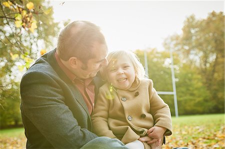 picture autumn london - Daughter sitting on father's lap smiling Stock Photo - Premium Royalty-Free, Code: 649-08901097