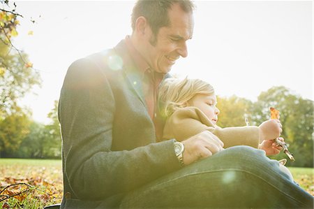 picture autumn london - Daughter sitting on father's lap holding autumn leaf Stock Photo - Premium Royalty-Free, Code: 649-08901099