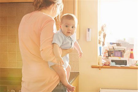 simsearch:649-07710656,k - Woman carrying baby son in arms in kitchen Stock Photo - Premium Royalty-Free, Code: 649-08901452