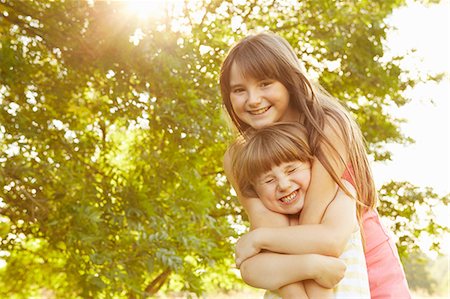 simsearch:614-06443089,k - Portrait of girl being hugged by big sister in park Foto de stock - Sin royalties Premium, Código: 649-08901502