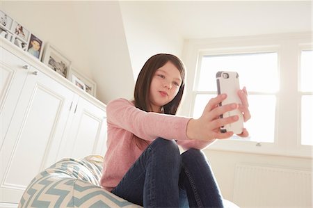 simsearch:649-08901712,k - Girl sitting on beanbag chair taking smartphone selfie Stock Photo - Premium Royalty-Free, Code: 649-08901524