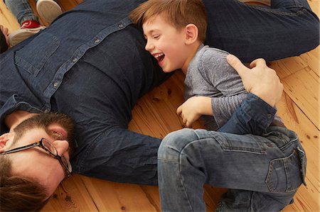 simsearch:649-07520662,k - Overhead view of boy and father laughing on floor Photographie de stock - Premium Libres de Droits, Code: 649-08901554