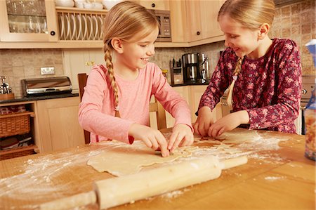 Two girls baking together at kitchen table Stock Photo - Premium Royalty-Free, Code: 649-08901572