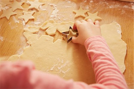 Over shoulder cropped view of girl making star shape pastry at kitchen table Foto de stock - Sin royalties Premium, Código: 649-08901573