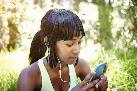 south africa and young adult and music and one person - Young woman in rural setting, using smartphone, wearing earphones Stock Photo - Premium Royalty-Free, Code: 649-08901810