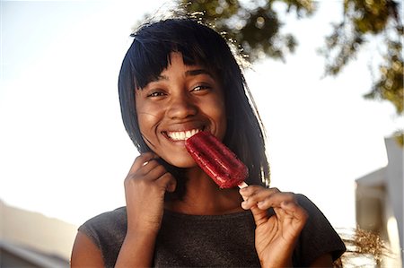 fresh-faced - Portrait of young woman, outdoors, eating ice lolly Stock Photo - Premium Royalty-Free, Code: 649-08901836