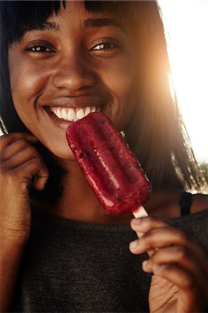 fresh-faced - Portrait of young woman, outdoors, eating ice lolly Stock Photo - Premium Royalty-Free, Code: 649-08901837