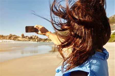 simsearch:649-08901850,k - Mature woman on beach, taking selfie, using smartphone, rear view Photographie de stock - Premium Libres de Droits, Code: 649-08901839