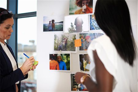 dictando - Colleagues in office discussing photographs on wall Foto de stock - Sin royalties Premium, Código: 649-08902052