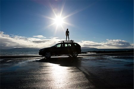 simsearch:695-05777089,k - Boy standing on surf board on top of a car, looking out to sea Photographie de stock - Premium Libres de Droits, Code: 649-08902072