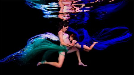 swimsuit underwater posing - Underwater view of young pregnant woman and girl poised together in darkness Stock Photo - Premium Royalty-Free, Code: 649-08902241