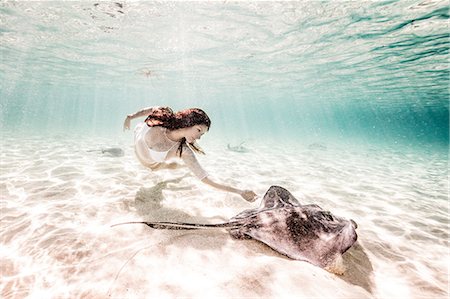 freediving - Female free diver swimming with stingray on seabed Stock Photo - Premium Royalty-Free, Code: 649-08902261