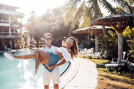 Young man carrying girlfriend in arms at poolside, Koh Samui, Thailand Foto de stock - Sin royalties Premium, Código: 649-08902270