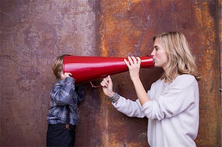 simsearch:6122-07706907,k - Woman speaking into megaphone, young boy listening, head in megaphone Foto de stock - Sin royalties Premium, Código: 649-08902338