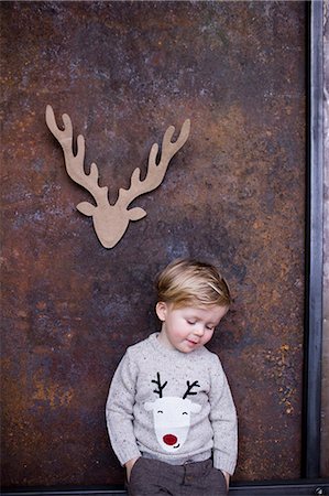 simsearch:649-08901706,k - Portrait of young boy, cardboard reindeer cut out on wall behind him Foto de stock - Royalty Free Premium, Número: 649-08902339