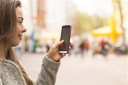 europe pedestrian mall - Young woman looking at smartphone on pedestrian street Stock Photo - Premium Royalty-Free, Code: 649-08924015