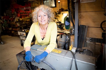 simsearch:649-08924077,k - Portrait of woman in bicycle repair shop Photographie de stock - Premium Libres de Droits, Code: 649-08924082