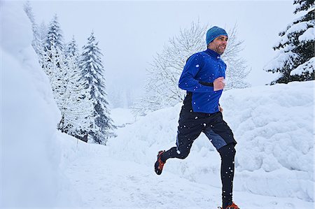 Male runner running on track in deep snow, Gstaad, Switzerland Stock Photo - Premium Royalty-Free, Code: 649-08924194