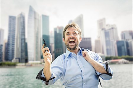 simsearch:649-08714633,k - Ecstatic businessman holding smartphone on city waterfront Photographie de stock - Premium Libres de Droits, Code: 649-08924239