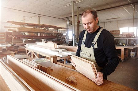 simsearch:649-07710267,k - Male carpenter inspecting wood plank at workbench Foto de stock - Sin royalties Premium, Código: 649-08924248