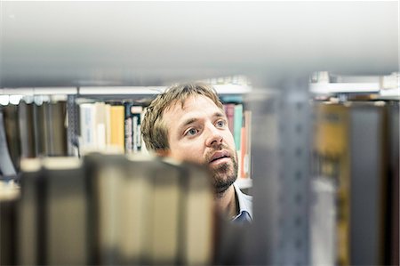 Businessman looking at file shelves in office storeroom Photographie de stock - Premium Libres de Droits, Code: 649-08924242