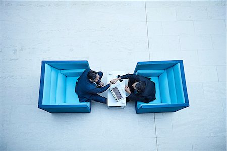 people meeting - Overhead view of businessmen shaking hands in office atrium Stock Photo - Premium Royalty-Free, Code: 649-08924284