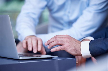 simsearch:649-08924310,k - Close up of businessmen using laptop at office meeting Stock Photo - Premium Royalty-Free, Code: 649-08924309