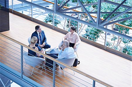 simsearch:649-08117870,k - High angle view of businessmen and businesswomen meeting on office balcony Photographie de stock - Premium Libres de Droits, Code: 649-08924313