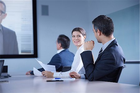 simsearch:649-07596189,k - Businesswoman looking over her shoulder during office conference call Photographie de stock - Premium Libres de Droits, Code: 649-08924344