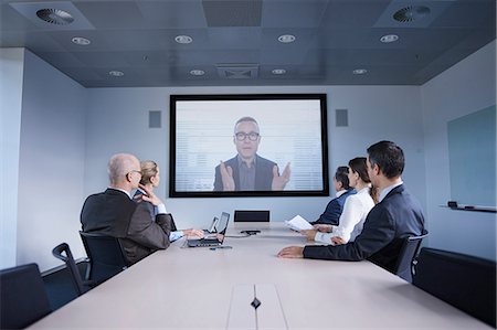 simsearch:649-08924324,k - Businessmen and women watching office conference call Stockbilder - Premium RF Lizenzfrei, Bildnummer: 649-08924349