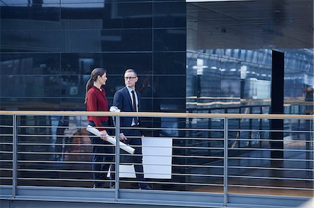 simsearch:614-07708118,k - Businesswoman and man walking and talking on office balcony Stock Photo - Premium Royalty-Free, Code: 649-08924375