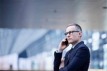 simsearch:649-08180080,k - Stressed businessman making smartphone call in office atrium Stock Photo - Premium Royalty-Free, Code: 649-08924372