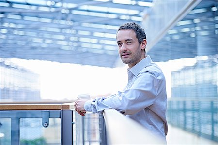 simsearch:649-08923486,k - Businessman looking out from office balcony Photographie de stock - Premium Libres de Droits, Code: 649-08924409