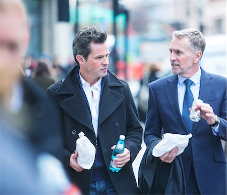 Businessmen walking in street carrying lunch Stockbilder - Premium RF Lizenzfrei, Bildnummer: 649-08924778