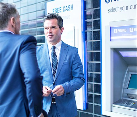 people outside building - Businessmen talking by cash machine Foto de stock - Sin royalties Premium, Código: 649-08924788