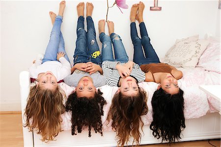 simsearch:649-08924834,k - Girls lying upside down on bed looking at camera Photographie de stock - Premium Libres de Droits, Code: 649-08924833