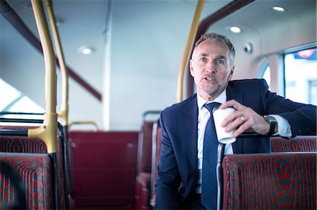 simsearch:614-08926442,k - Businessman with takeaway coffee on double decker bus Stock Photo - Premium Royalty-Free, Code: 649-08924919