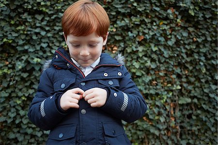 simsearch:649-08563671,k - Portrait of red haired boy in front of ivy wall fidgeting with hands Stock Photo - Premium Royalty-Free, Code: 649-08922689
