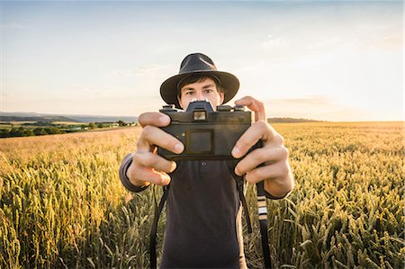 simsearch:649-08895049,k - Mid adult man, standing in field, taking selfie with SLR camera, Neulingen, Baden-Württemberg, Germany Photographie de stock - Premium Libres de Droits, Code: 649-08922736